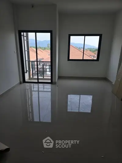 Spacious empty room with large windows and mountain view, perfect for customization.