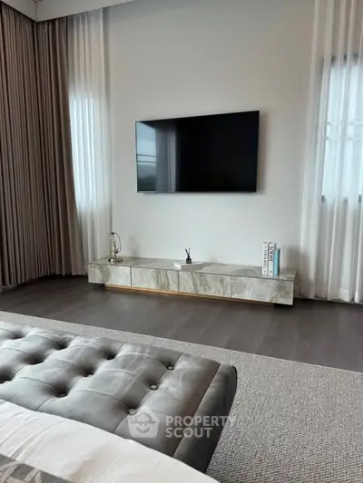 Luxurious modern bedroom with sleek TV setup and elegant decor
