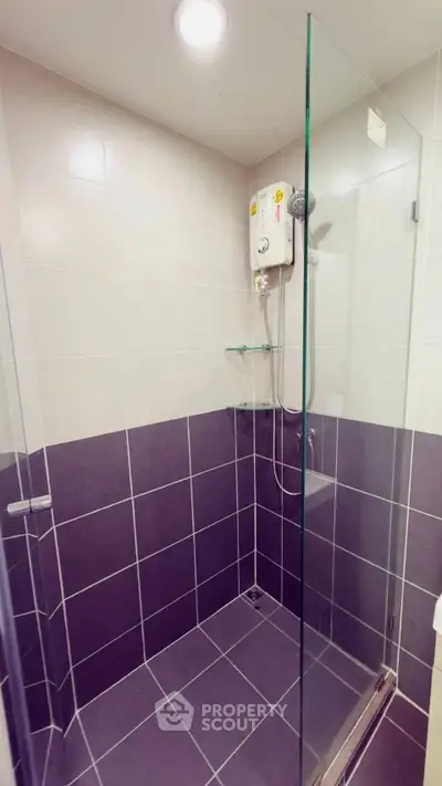 Modern bathroom with glass shower enclosure and electric water heater