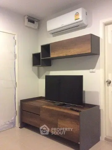 Modern living room with sleek wooden furniture and wall-mounted air conditioner.