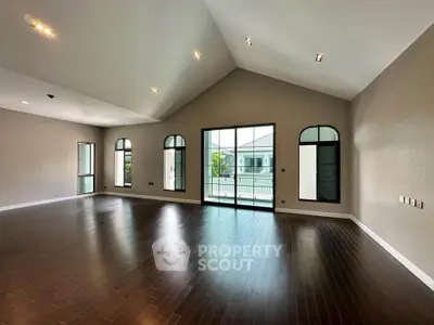 Spacious living room with high ceilings and large windows offering abundant natural light.