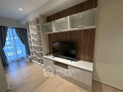 Modern living room with built-in TV unit and large window with city view.