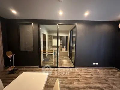 Modern interior with glass partition and wooden flooring in a stylish apartment.