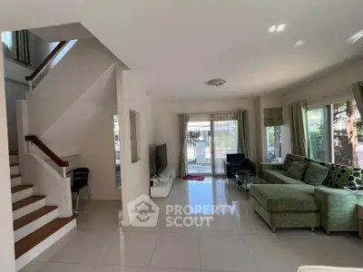 Spacious modern living room with large windows and stylish staircase