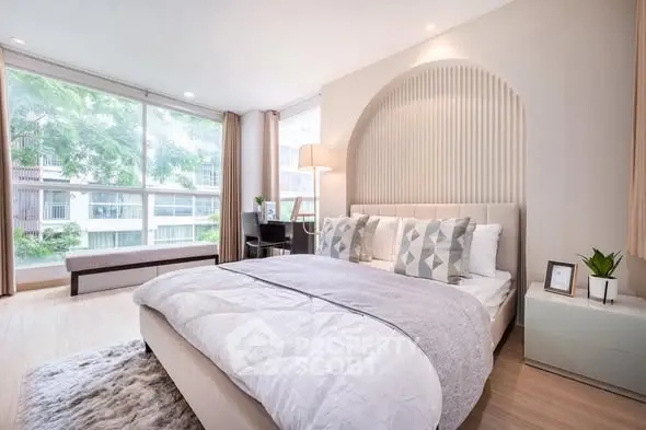 Luxurious bedroom with large windows and modern decor in a stylish apartment.