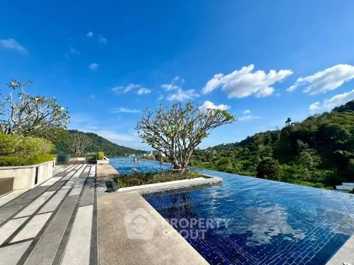 Stunning rooftop infinity pool with panoramic mountain views and lush greenery.