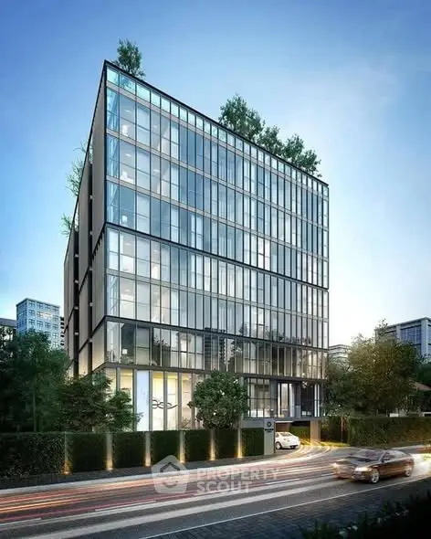 Modern glass facade building with lush greenery and sleek design in urban setting.