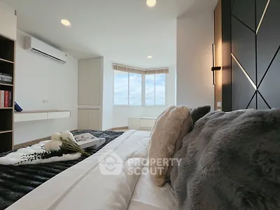 Luxurious bedroom with modern decor and large windows offering stunning views.