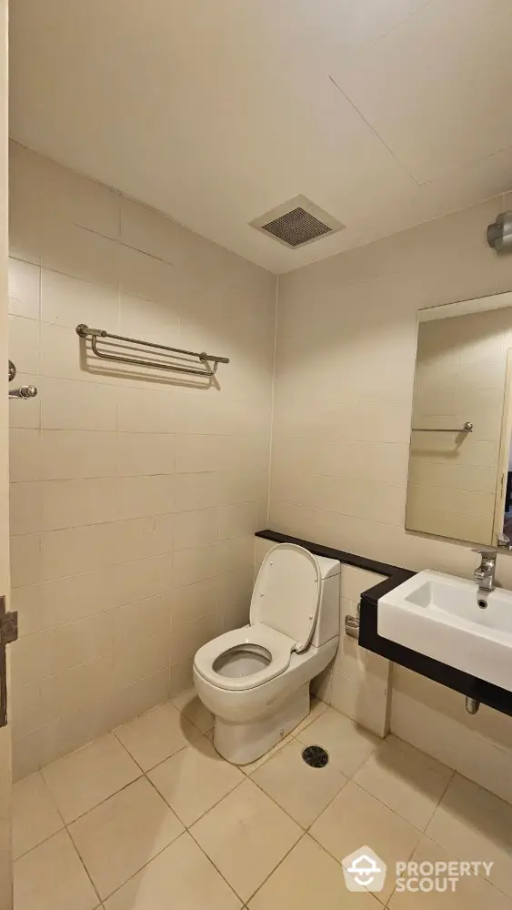 Modern bathroom with sleek fixtures and neutral tiles in a contemporary home.