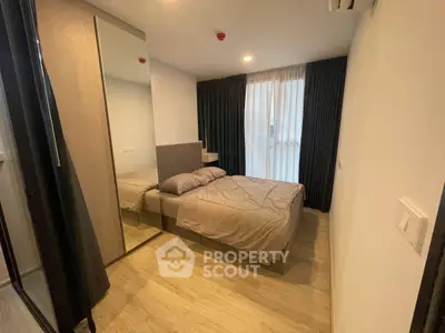 Modern bedroom with cozy bed, mirrored wardrobe, and elegant curtains in a stylish apartment.