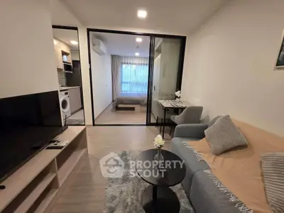 Modern apartment interior with cozy living room and view into bedroom, featuring stylish furniture and open layout.