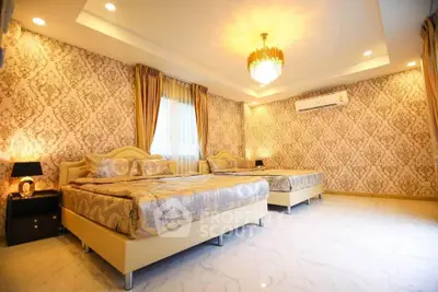 Luxurious bedroom with elegant wallpaper, two beds, and a chandelier, offering a sophisticated ambiance.