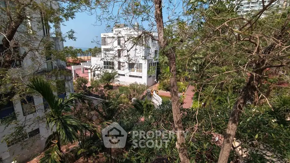 Lush garden view with modern white building and tropical trees