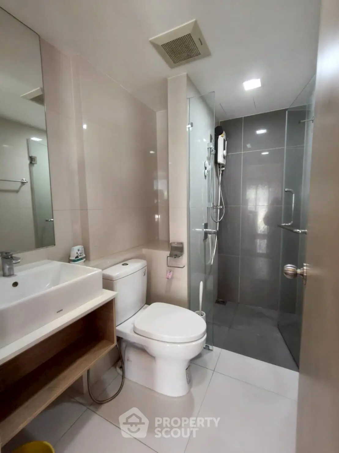 Modern bathroom with glass shower and sleek fixtures in contemporary apartment.
