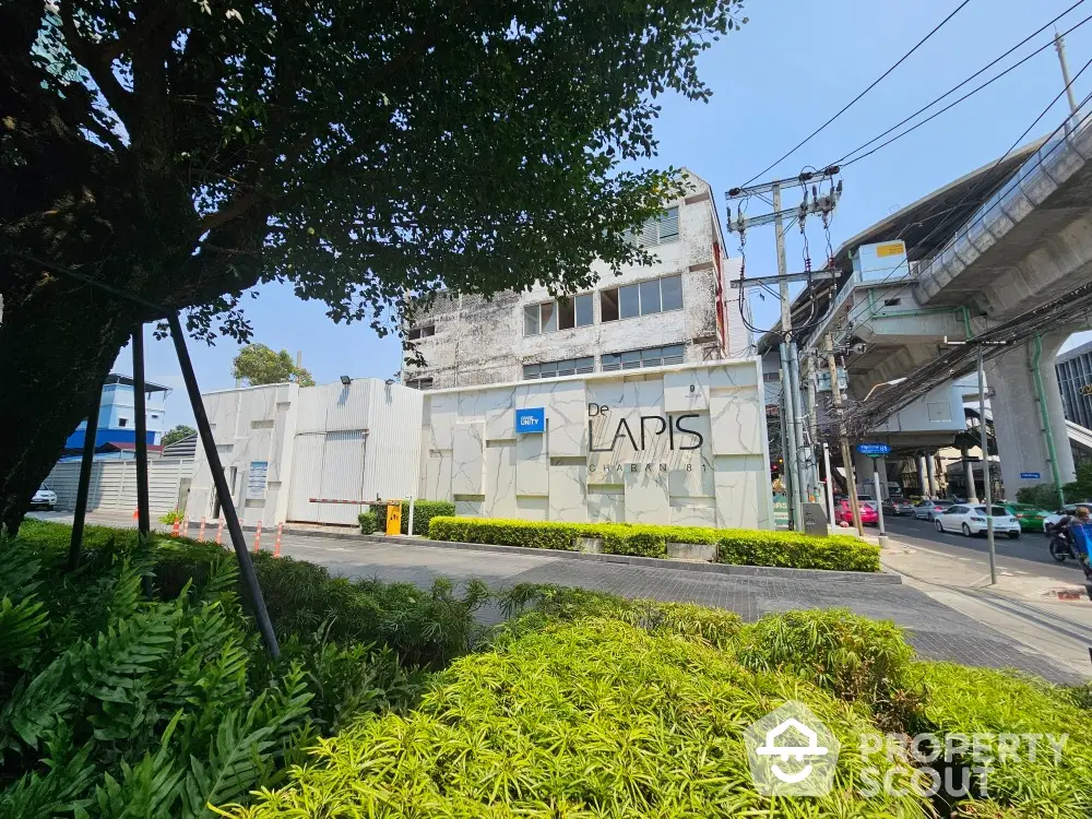 Modern urban building exterior with lush greenery and clear blue sky