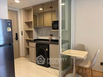 Modern compact kitchen with integrated appliances and cozy dining area