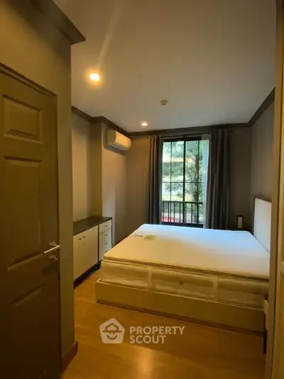 Cozy bedroom with large window and air conditioning, perfect for restful nights.
