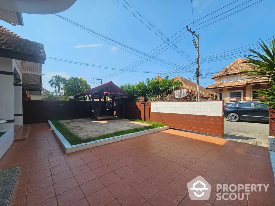 Charming residential property with spacious tiled patio and covered outdoor seating area.