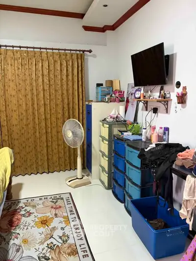Cozy bedroom with TV, fan, and ample storage space