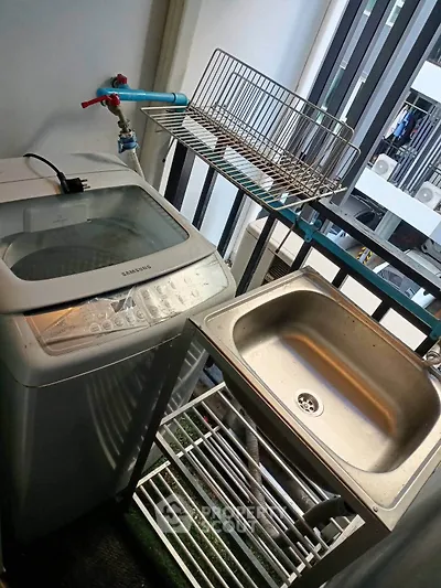 Compact balcony with washing machine and sink, ideal for urban living convenience.
