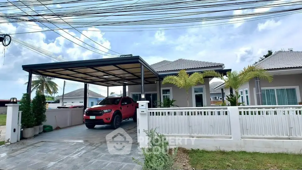Charming single-story home with carport and lush greenery in a serene neighborhood.
