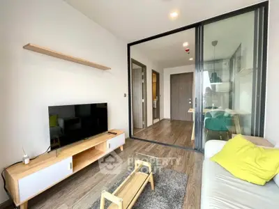 Modern living room with sleek furniture and glass partition in a stylish apartment.