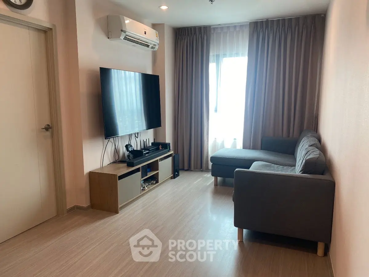 Modern living room with sleek furniture and large TV, perfect for relaxation.