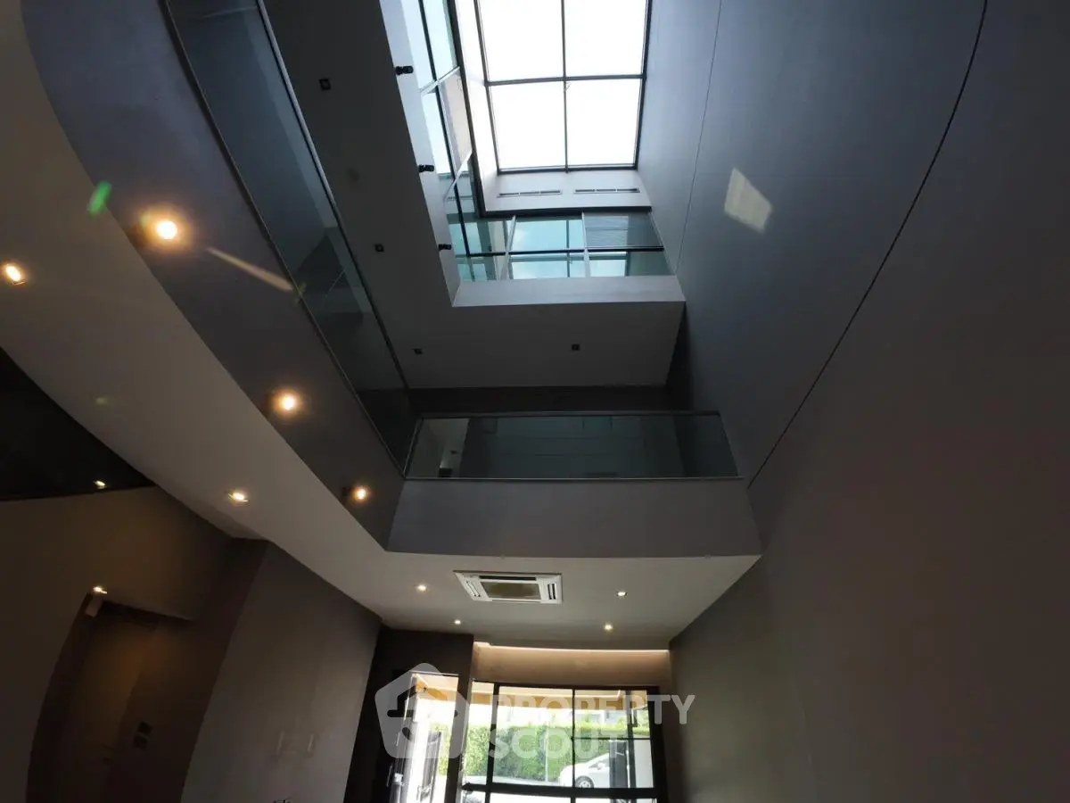 Modern building entrance with glass balconies and skylight