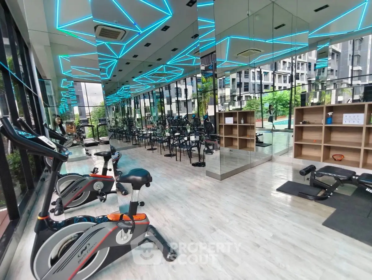 Modern gym with neon lighting and exercise equipment in a luxury building