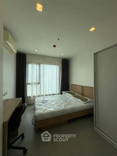 Modern bedroom with large window and minimalist design in a high-rise apartment.