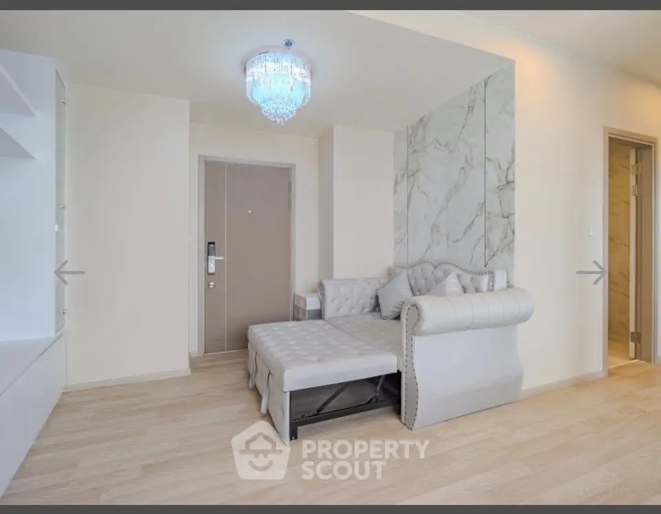 Elegant living room with luxurious sofa and modern chandelier in a stylish apartment.