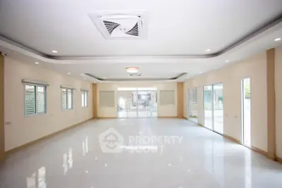 Spacious modern living room with large windows and elegant ceiling design.