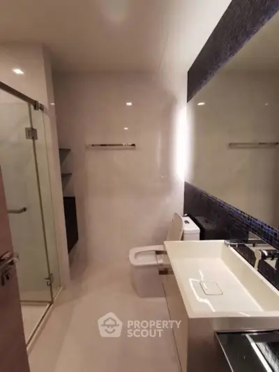 Modern bathroom with sleek fixtures and glass shower enclosure