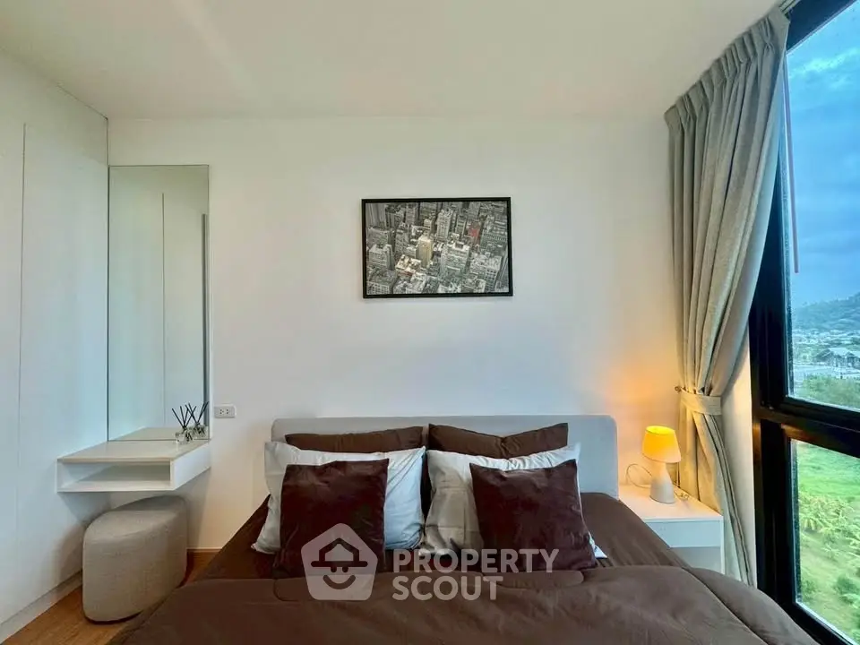 Cozy bedroom with modern decor and large window offering scenic views.