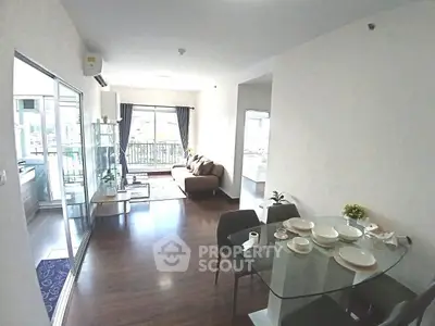 Spacious modern living room with glass dining table and balcony view