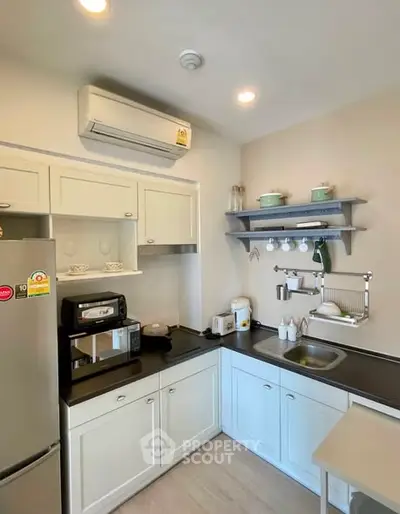 Charming kitchen with modern appliances and sleek cabinetry in cozy apartment.