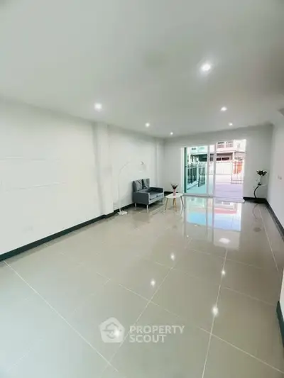 Spacious modern living room with glossy tiled floors and natural light