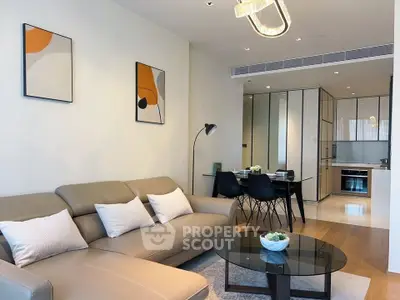 Modern living room with stylish decor and open kitchen layout, featuring a cozy sofa and elegant dining area.