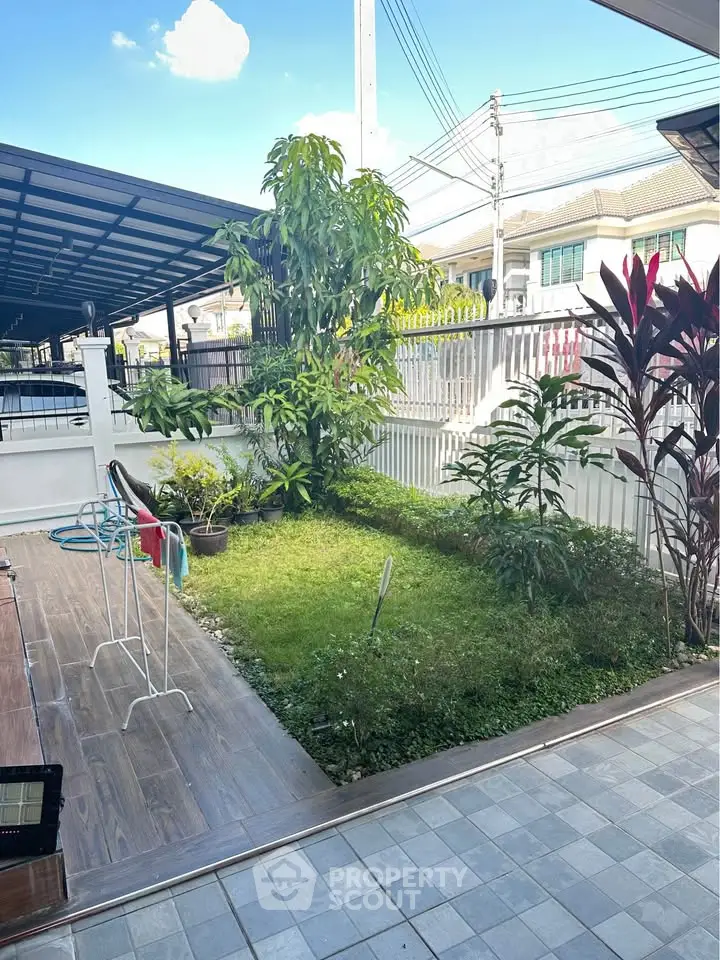 Charming garden view with lush greenery and tiled patio in a residential setting.