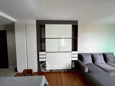 Modern living room with sleek storage unit and cozy gray sofa