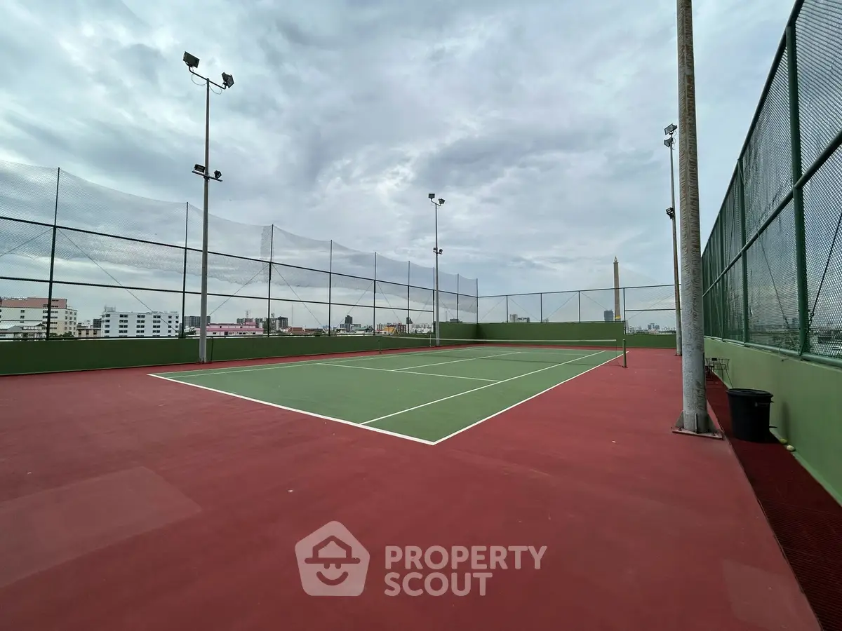 Spacious rooftop tennis court with city views, perfect for sports enthusiasts seeking urban living amenities.