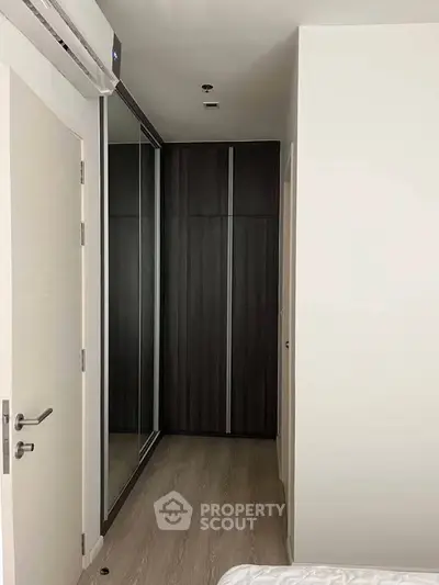 Modern bedroom with sleek mirrored wardrobe and minimalist design