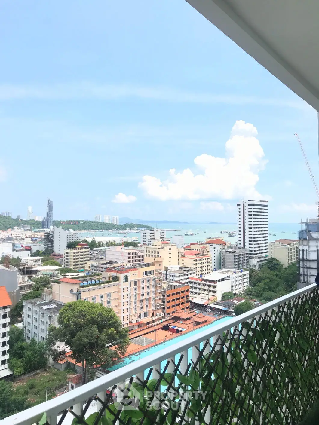 Stunning cityscape view from a high-rise balcony overlooking the ocean and skyline.