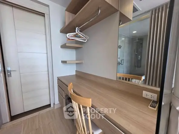Modern study room with wooden desk and shelves, featuring a sleek design and ample natural light.