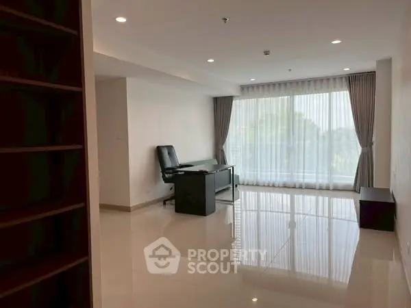 Spacious modern living room with large window and sleek flooring