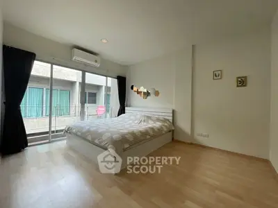 Spacious bedroom with modern decor and large windows in a stylish apartment.