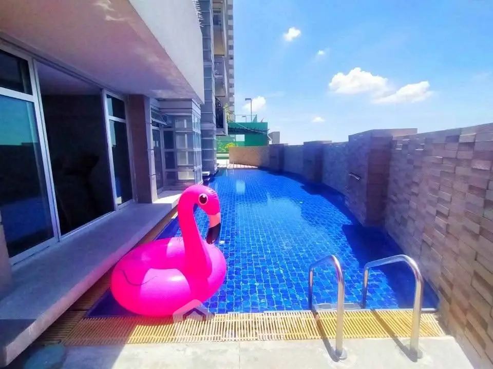 Luxurious rooftop pool with stunning city views and vibrant pink flamingo float.