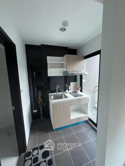 Modern compact kitchen with sleek design and large window for natural light