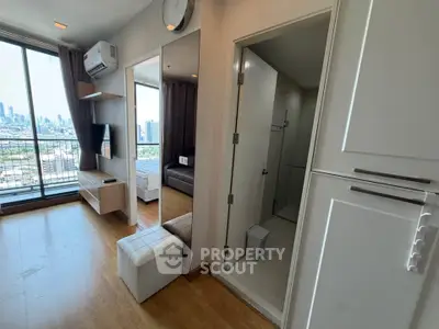 Modern apartment interior with city view, featuring a cozy living area and compact bathroom.