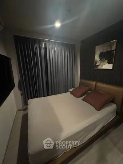 Cozy bedroom with modern decor and large window, perfect for relaxation and comfort.